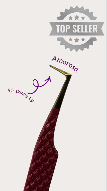 Red eyelash extension tool with gold tip labeled 'Amorosa' on a light gray background.